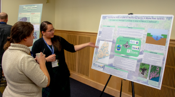 A photo of Beth Davis presenting a poster.