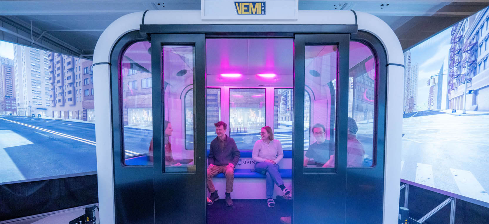 A photo of people sitting in a VEMI Lab simulator