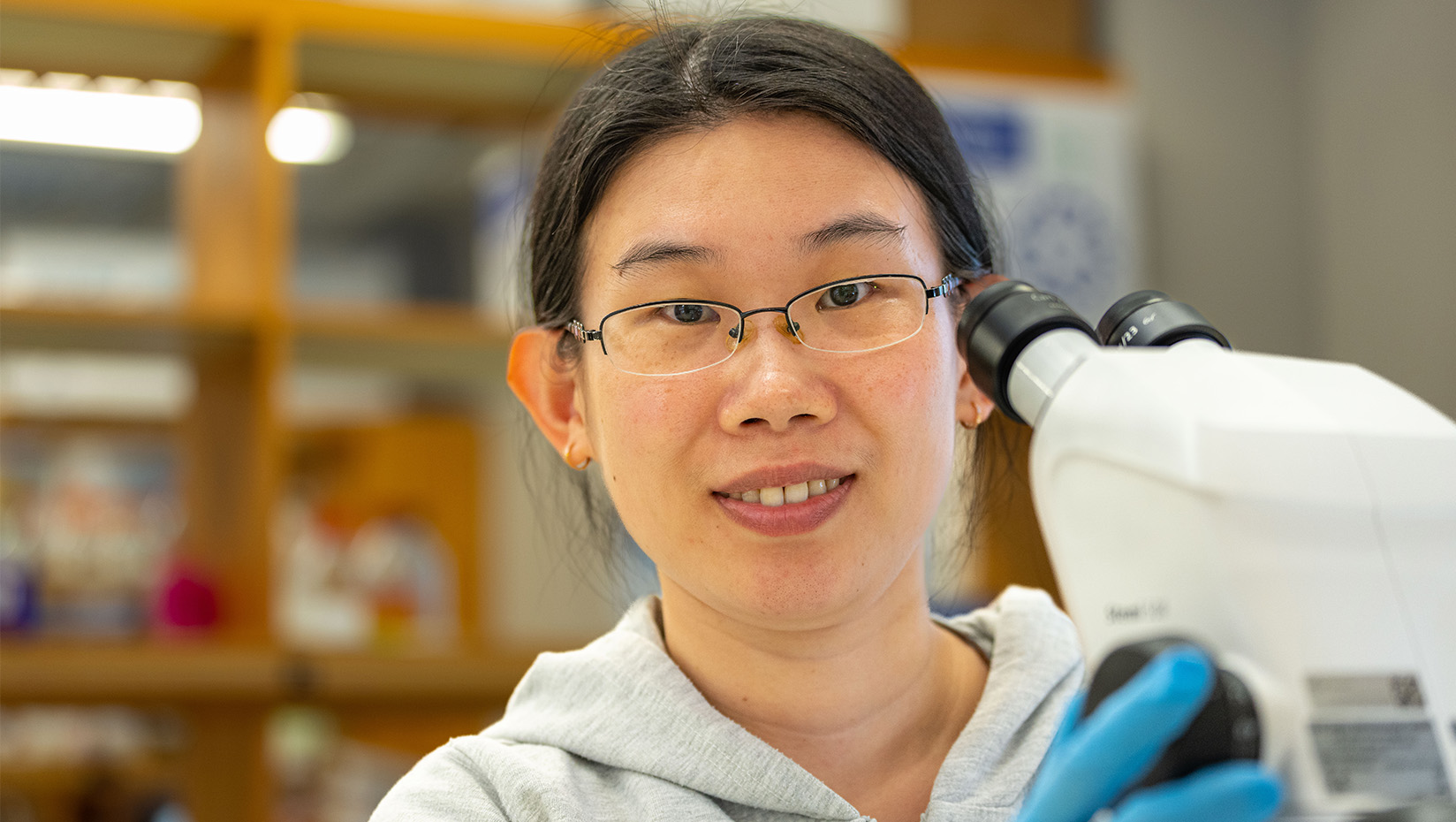 Researcher Zhao Xuan at a microscope.