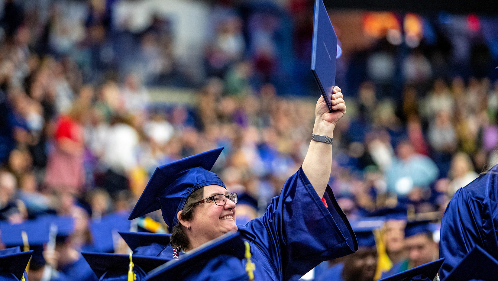 A photo of a graduate holding up her diploma