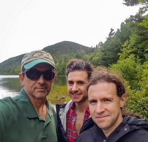 A photo of three people hiking near the Maine coast