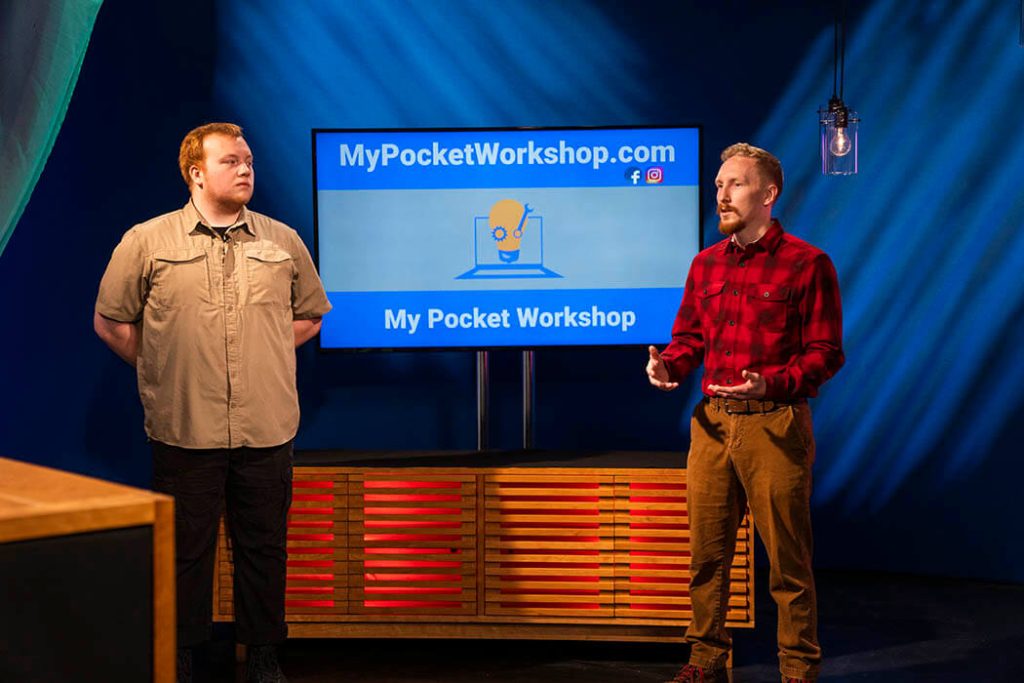 A photo of two Greenlight Maine participants standing in front of a screen