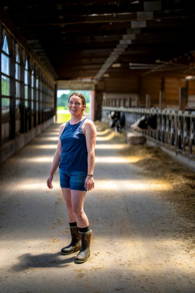 A photo of a woman standing in a barn