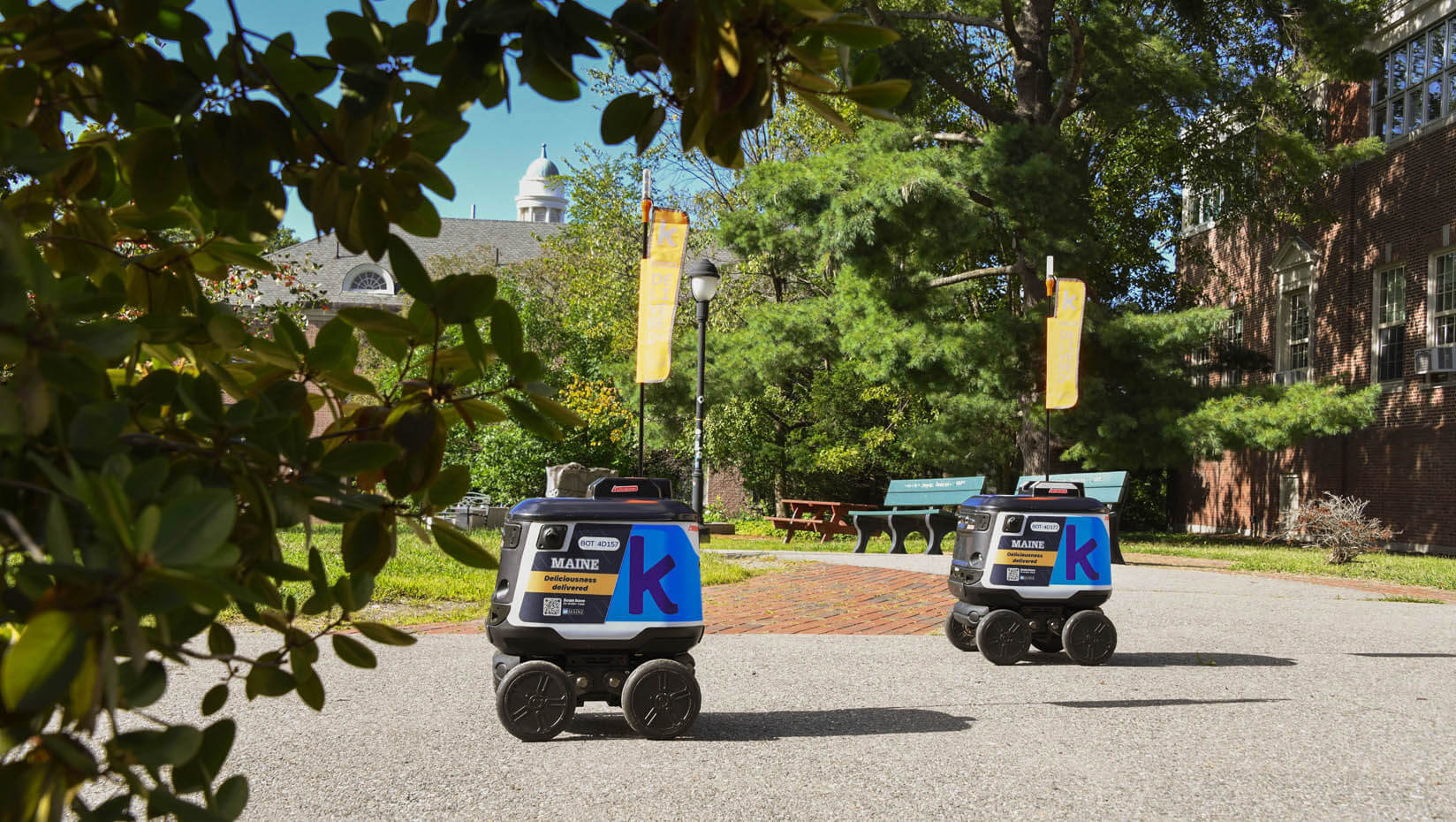 A photo of two Kiwibots driving outside of the Memorial Union