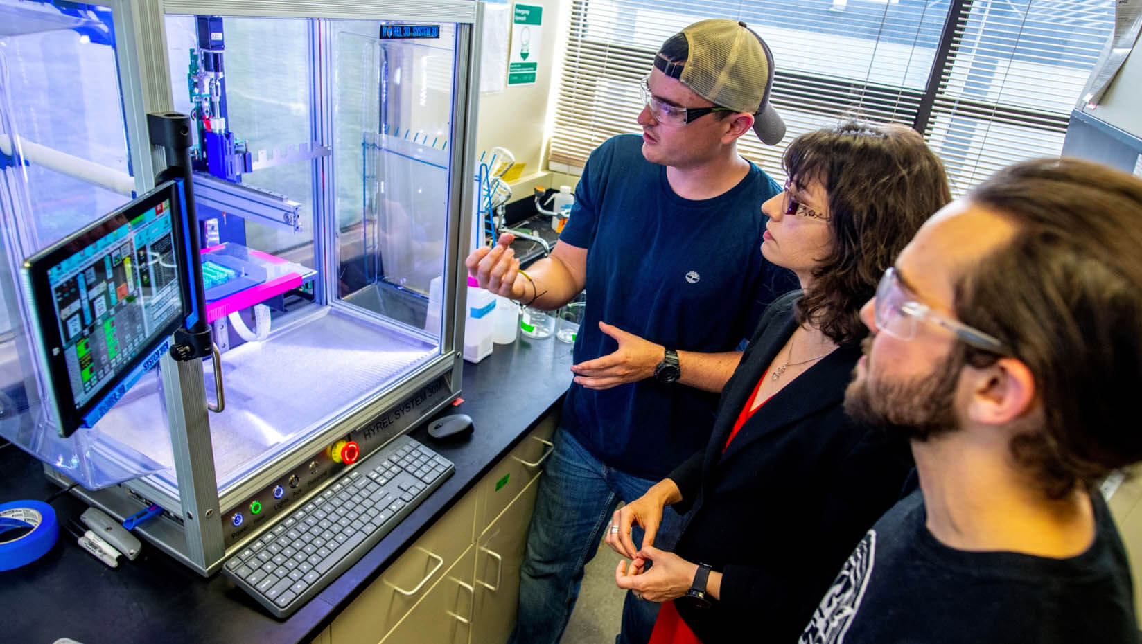 A photo of three people working in a lab