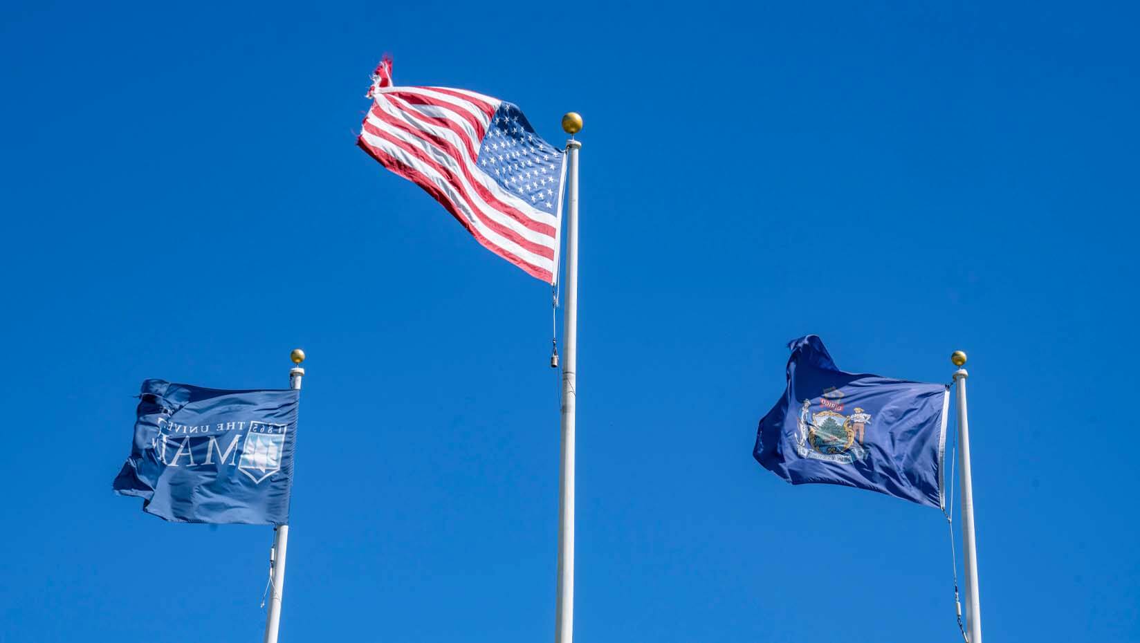 A photo of the UMaine flag, the U.S. flag and the state of Maine flag