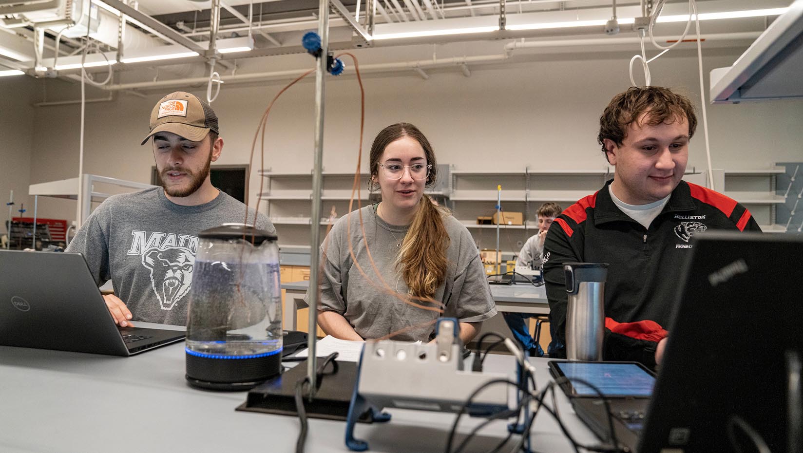 Photo of three people working in a lab, two of whom are using computers.