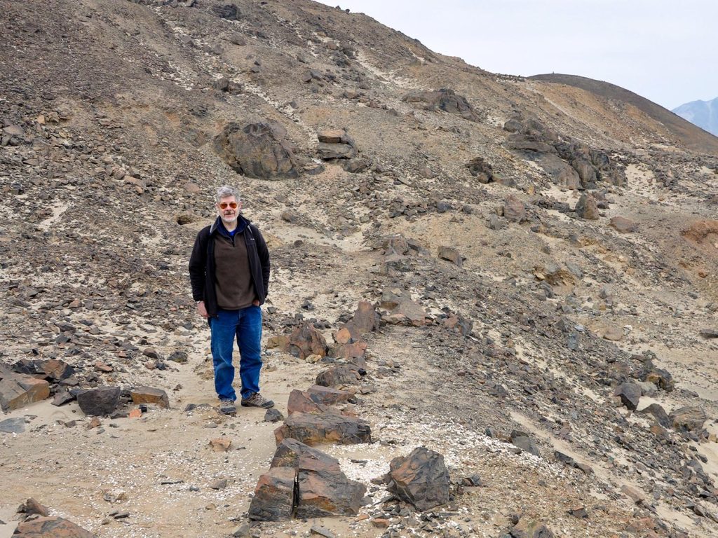 A photo of Dan Sandweiss in a rocky landscape