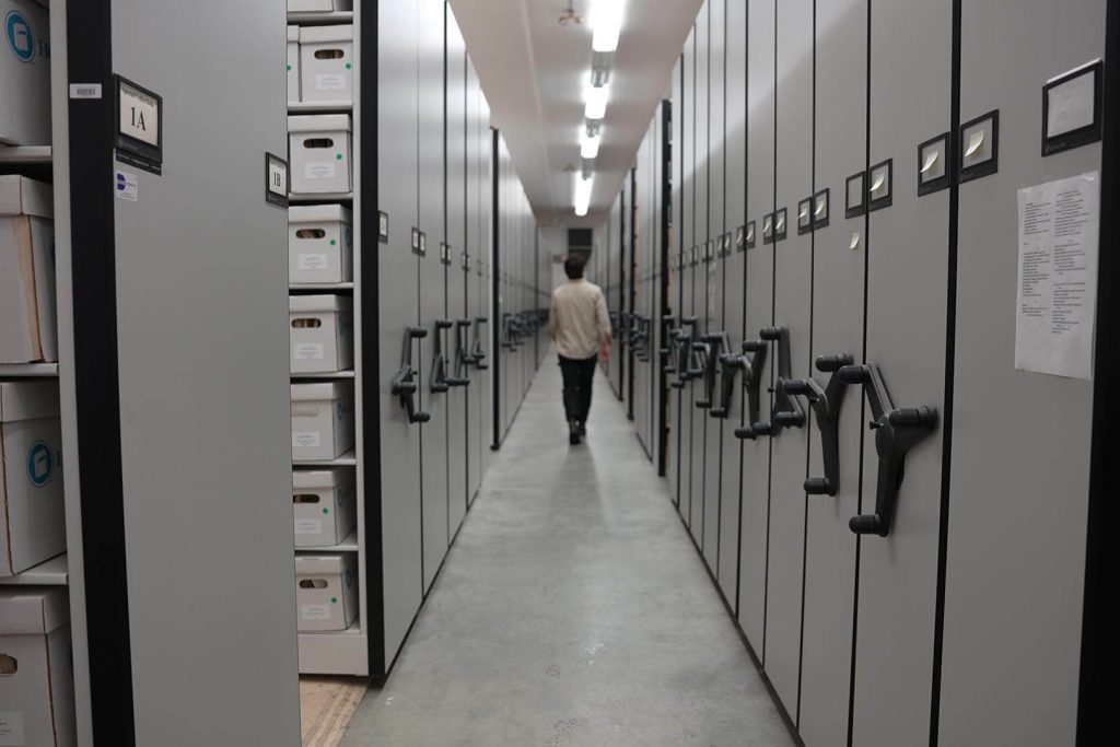 A photo of a person walking between shelves