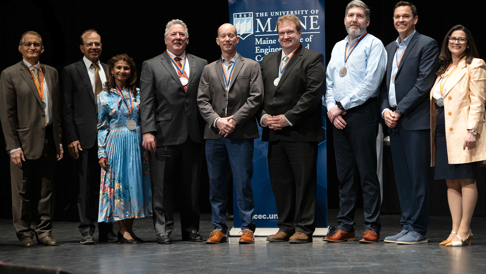 Photo of a group of people posing for a picture during an awards ceremony.