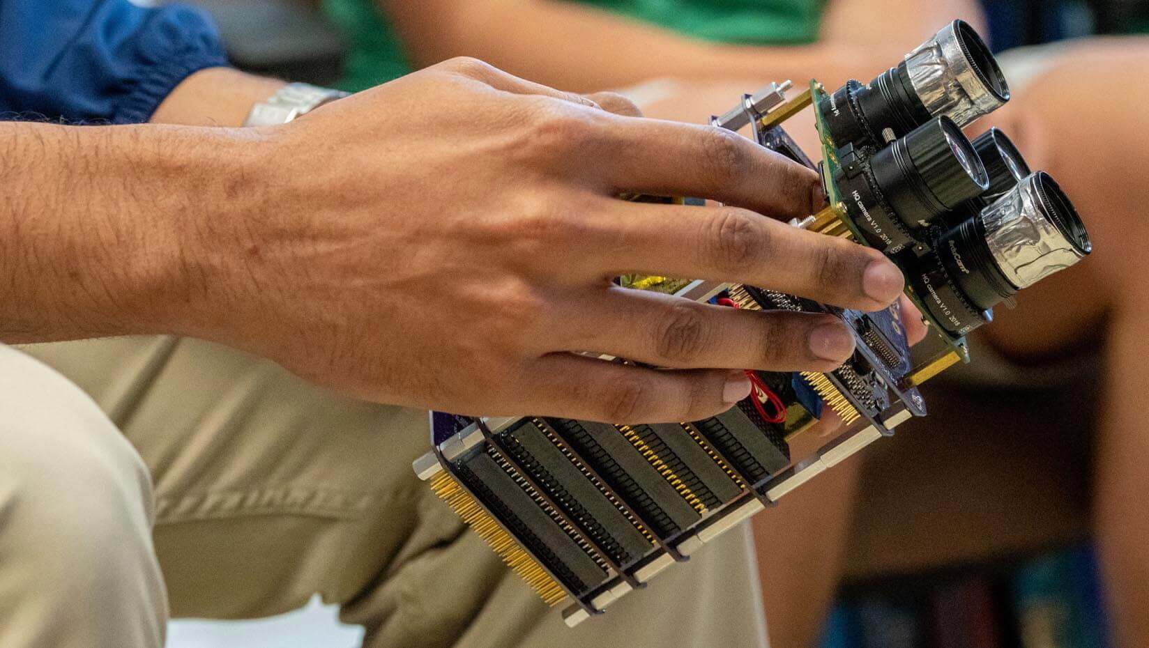A photo of hands holding the satellite module