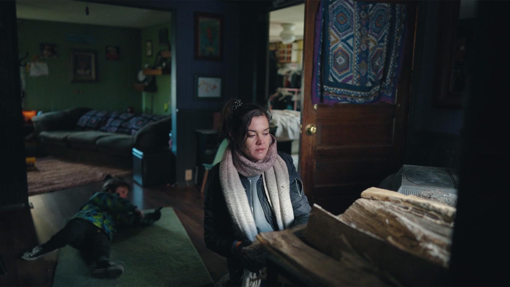 A photo of a person sitting at a desk in a dark room.