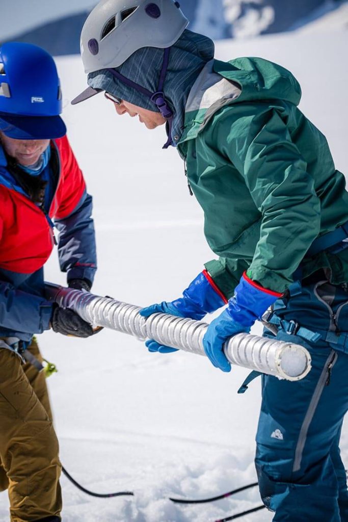 A photo of two people holding an ice core