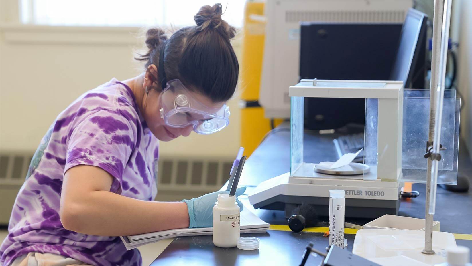 A photo of a student working in a lab with a microscope