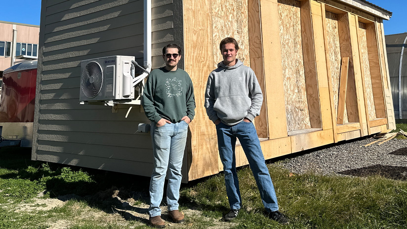 Photo of two people standing in front of a house.