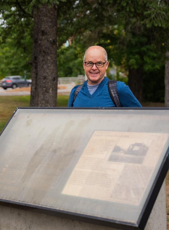 A photo of a man behind a sign