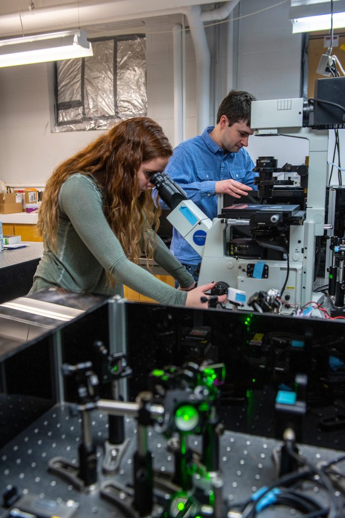 A photo of a student looking through a microscope