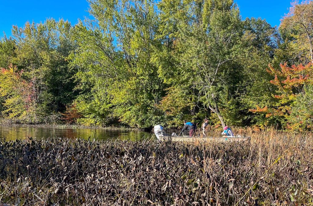 A photo of three people on a boat in a Maine river.