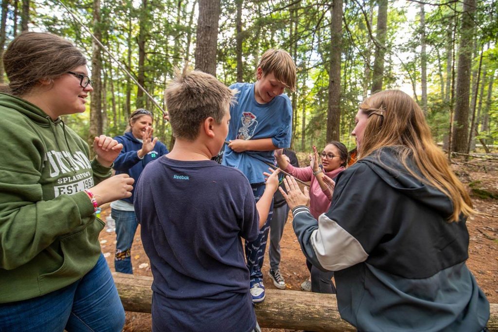 A photo of kids participating in a team activity in a forest