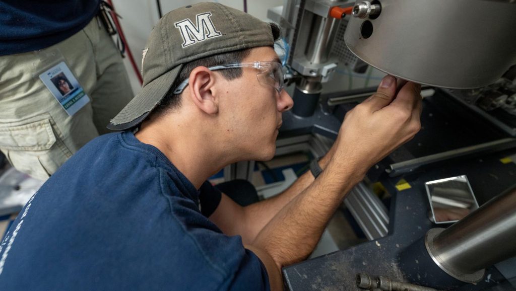 A photo of a person working with a machine in an engineering lab
