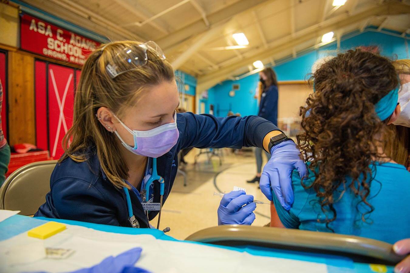 University of Maine nursing student Michaela Cisowski vaccinates a child