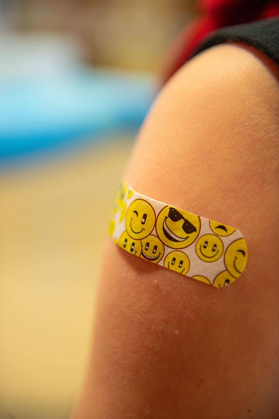 A vaccine recipient shows off their bandage