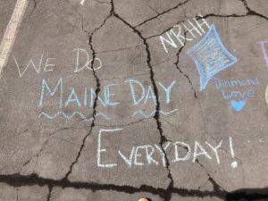 concrete with chalk writing 'We do Maine Day Everyday!'