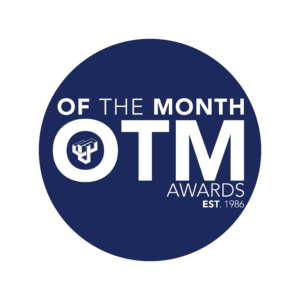 Blue circle with white wording "Of the Month (OTM) Awards Est. 1986"