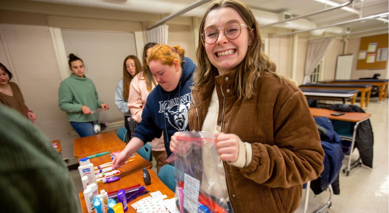 A photo of a smiling student bagging crafts