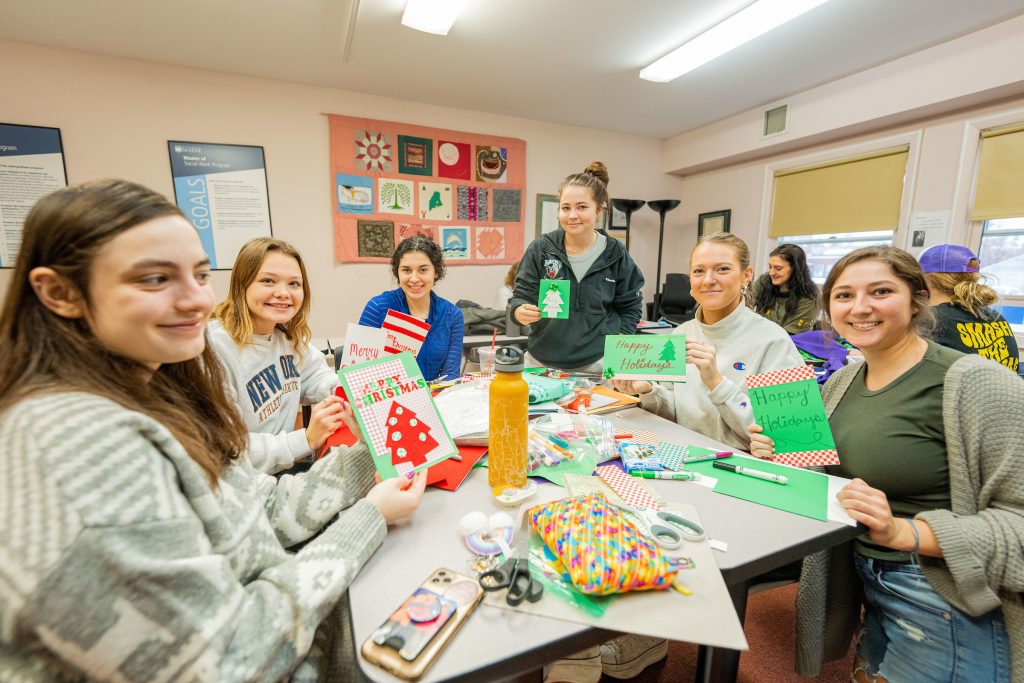 Students in the social work class wraps presents, drop off gifts, and make cards for students at the Bangor Adoptive and Foster Families of Maine