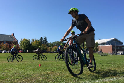 Students biking around a field.