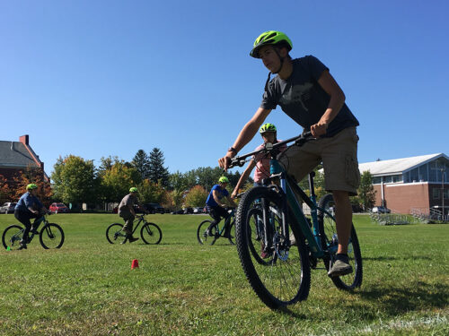 Students biking around a field.