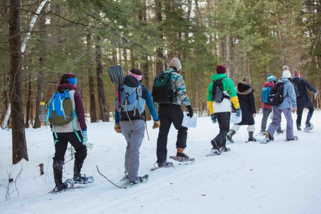 line of umaine students snowshoeing