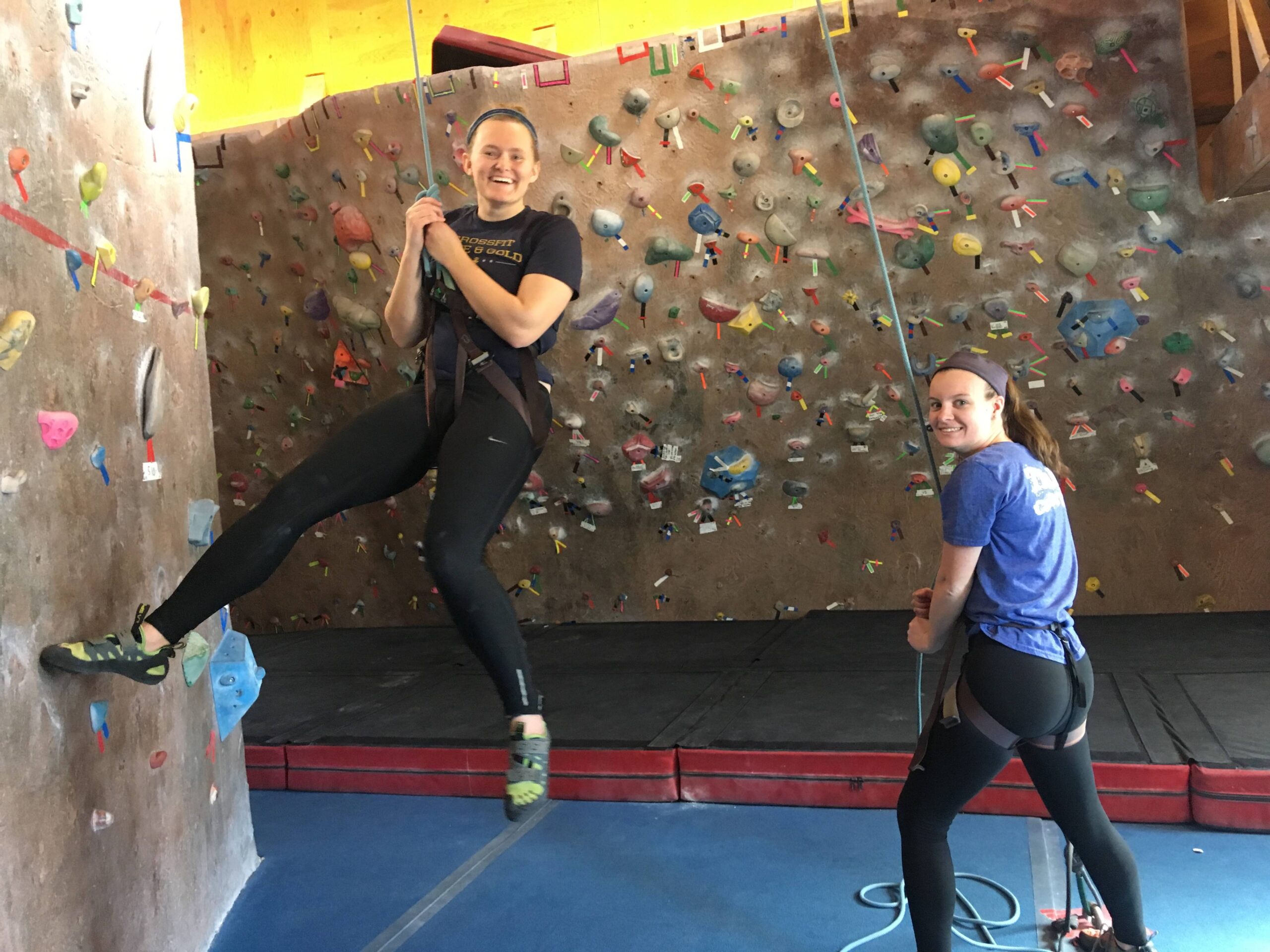 Photo of climber and belayer smiling at camera as climber is lowered.