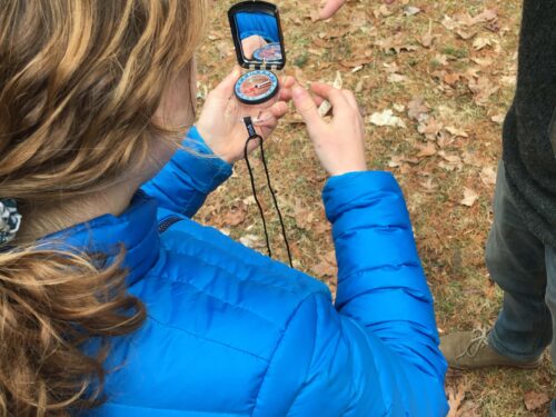 Student using a mirrored compass to take a bearing.