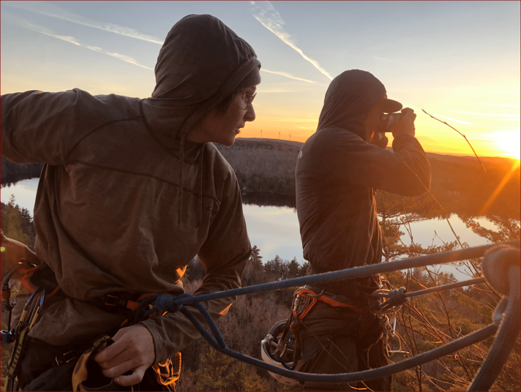 Rock climbers taking pictures of a sunset.