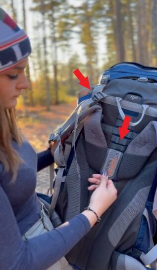 Hiker adjusting backpack load lifers and shoulder straps.