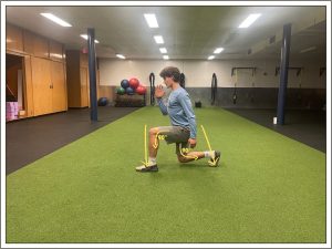 A student demonstrating the third step of alternating lunge jumps