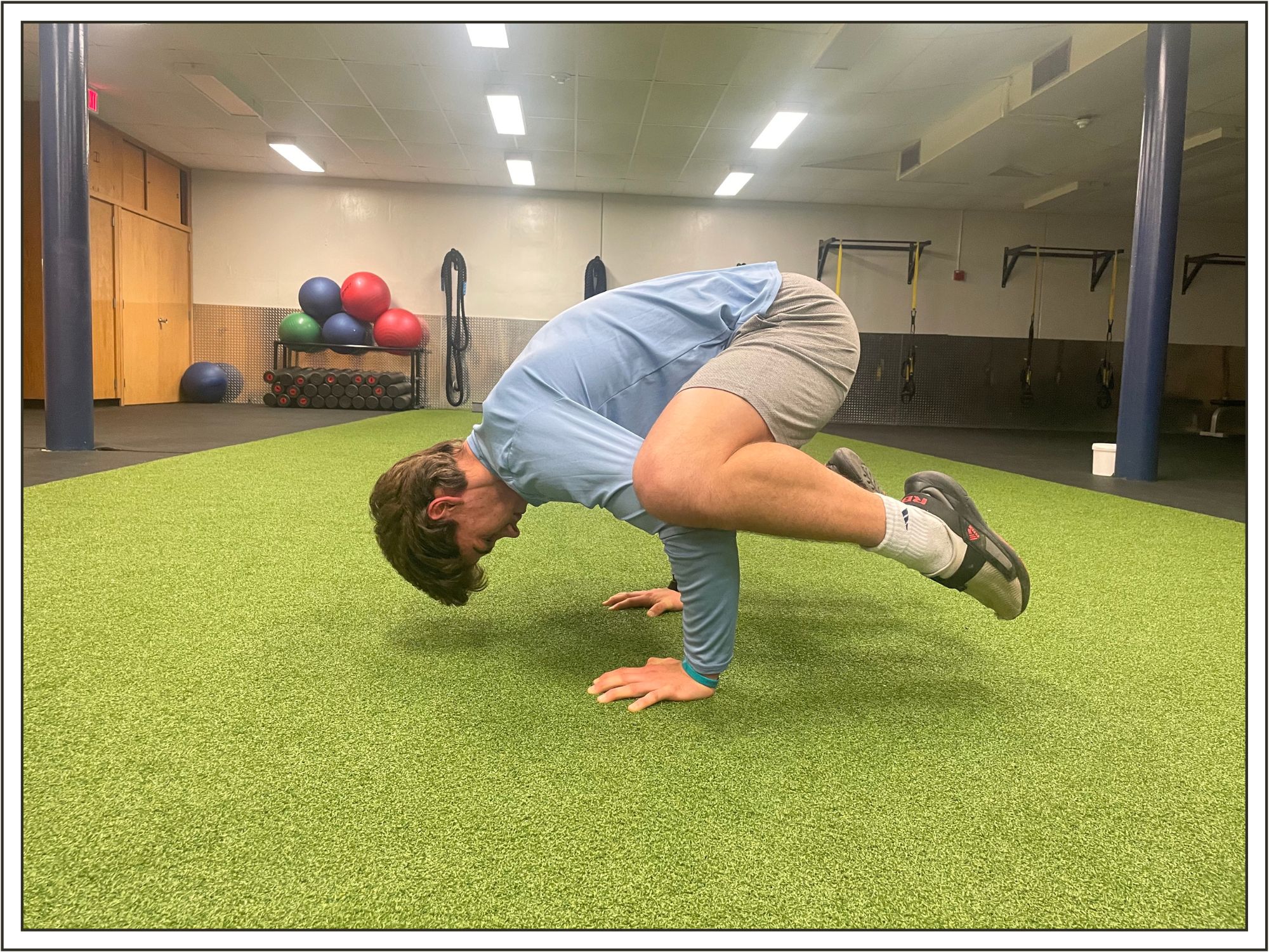 A student demonstrating crow pose