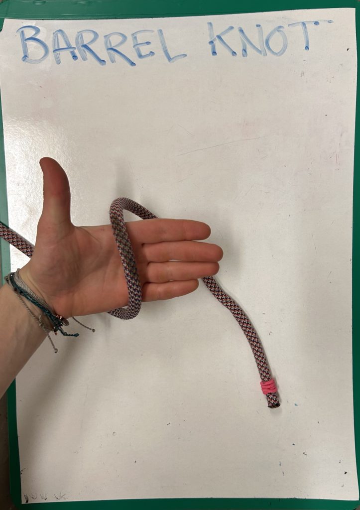 hand holding rope and demonstrating 'barrel knot'