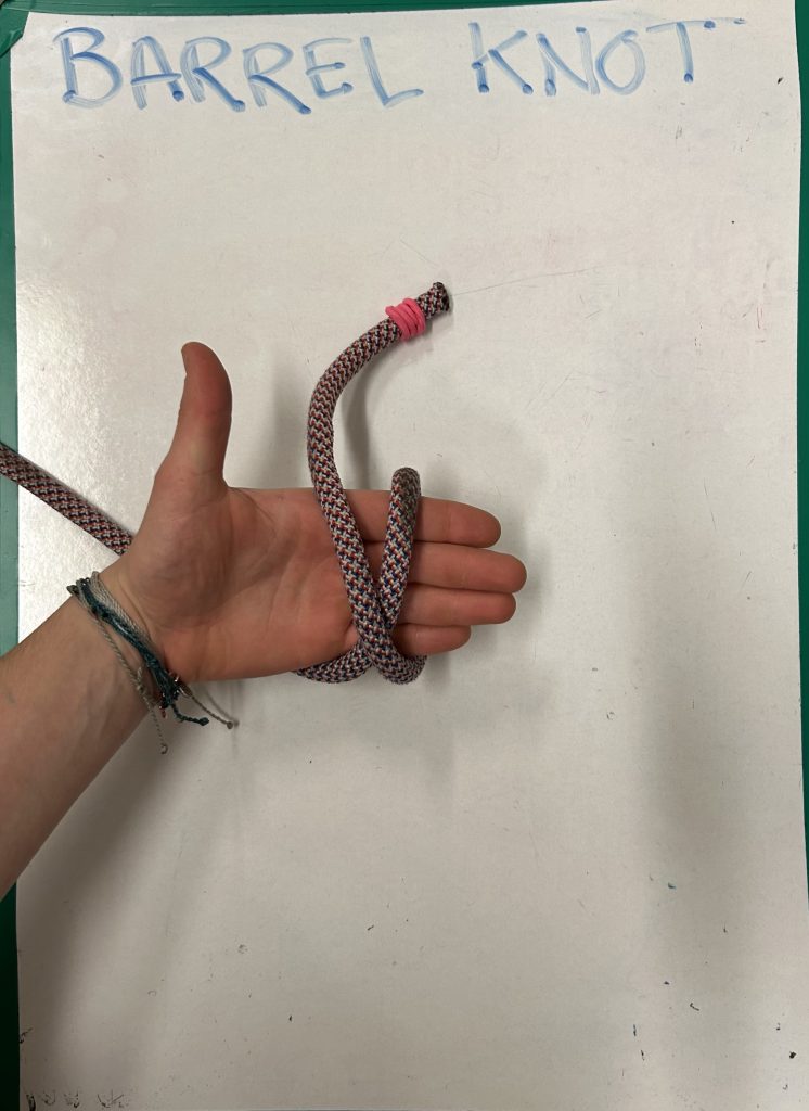 hand holding rope and demonstrating 'barrel knot'