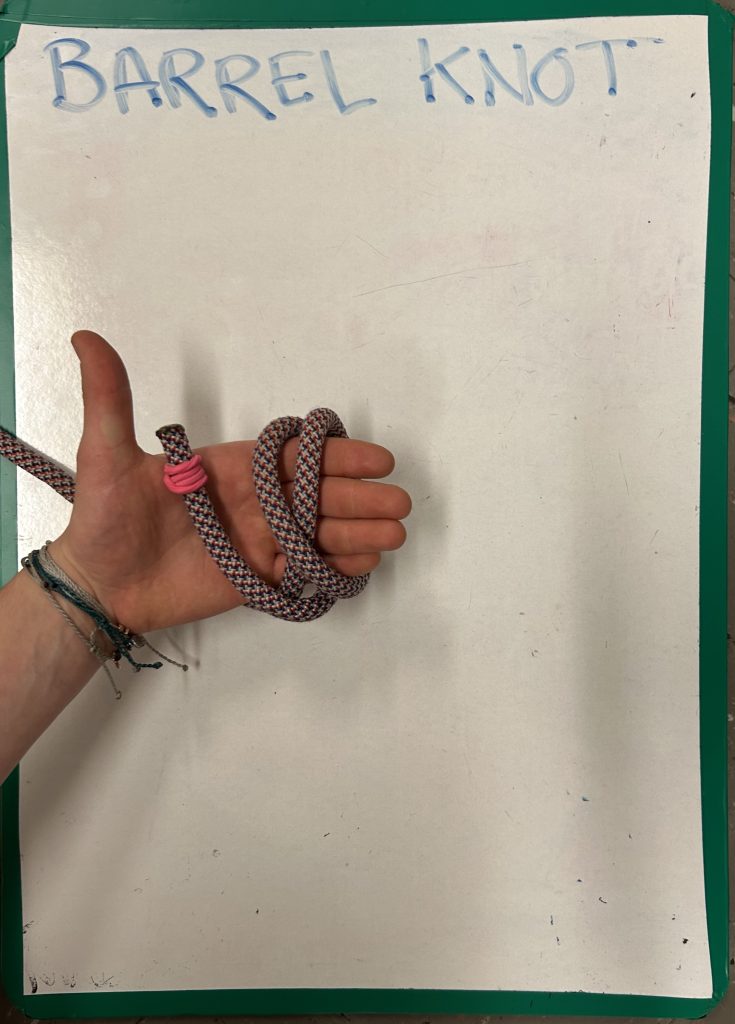 hand holding rope and demonstrating 'barrel knot'