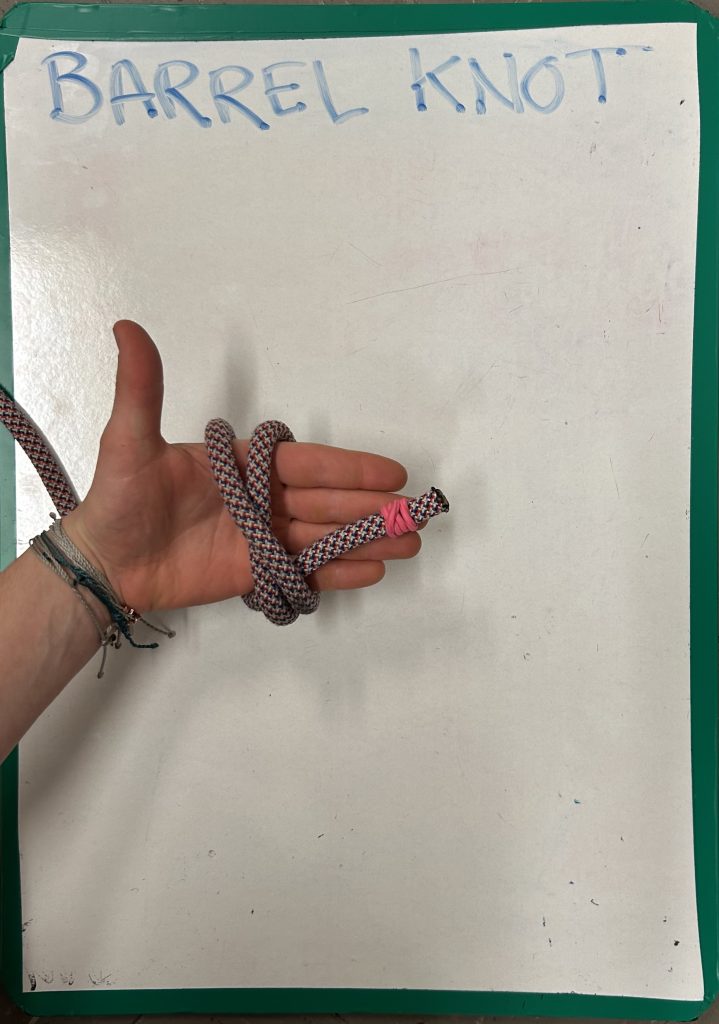 hand holding rope and demonstrating 'barrel knot'