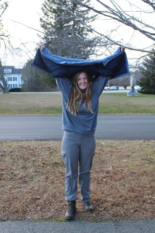 Student with a coat over their head, to look big against a bear.