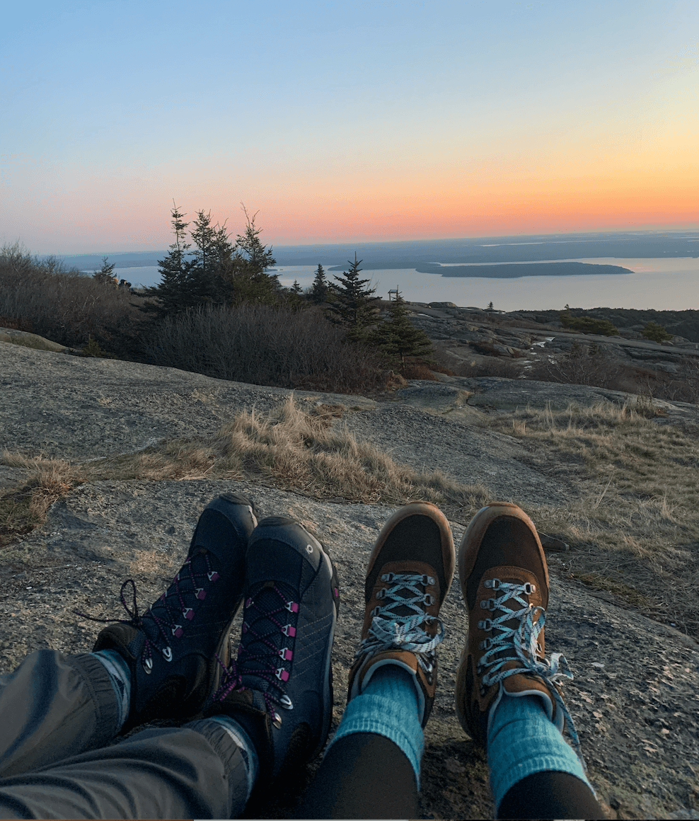 Two pairs of hiking boots on a landscape