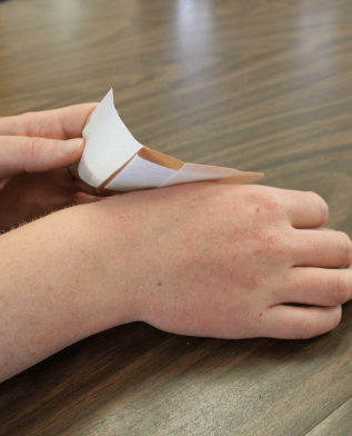 Student applying a bandaid.