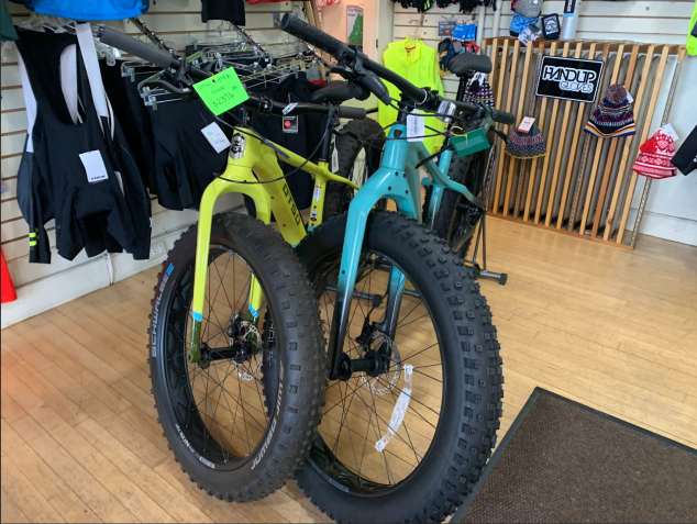 Two fat bikes of different colors on display in a bike shop