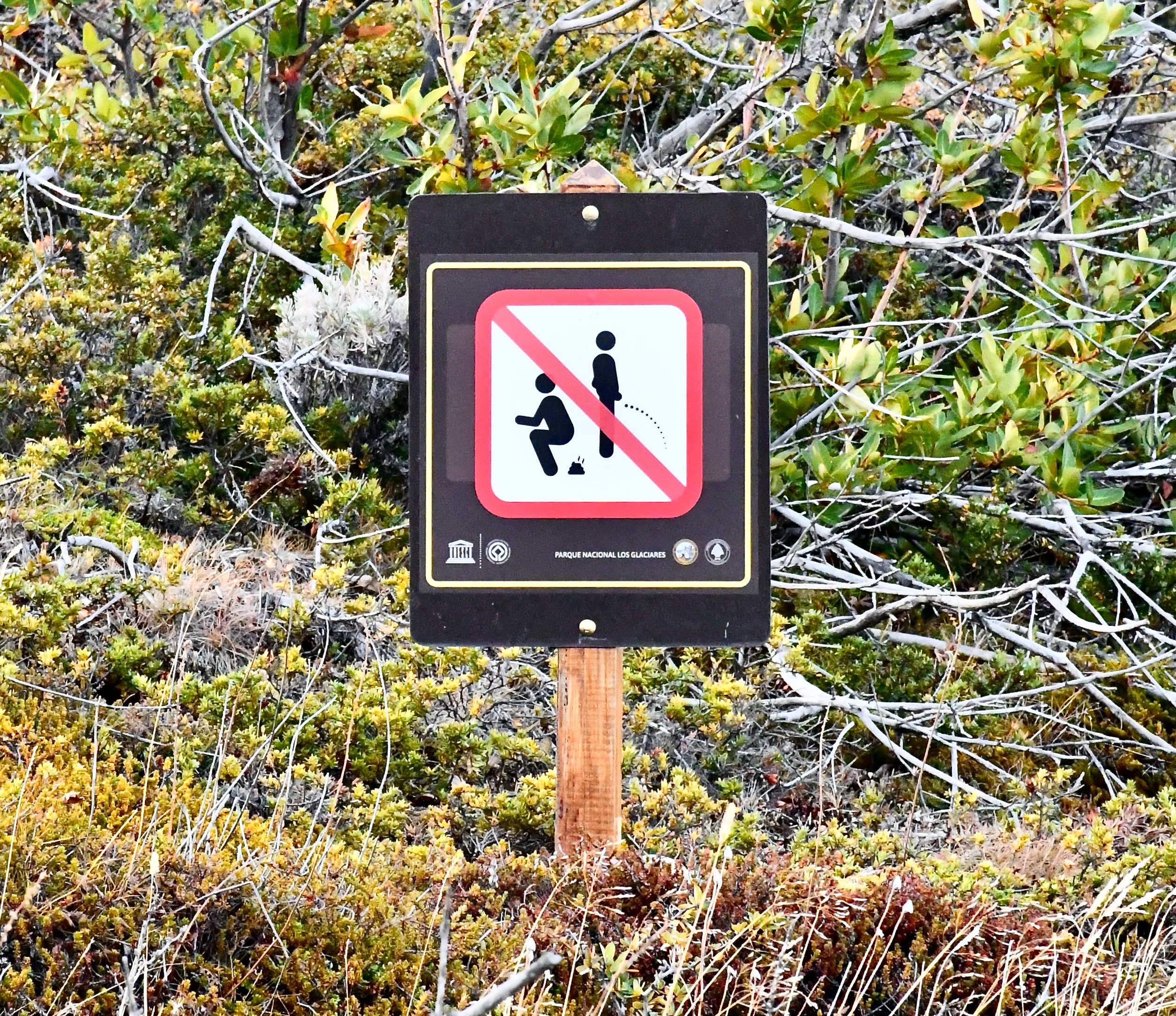 Image of a park sign prohibiting off-trail deification and urination.