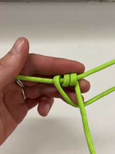 Loop of green cord with three small loops around standing end.