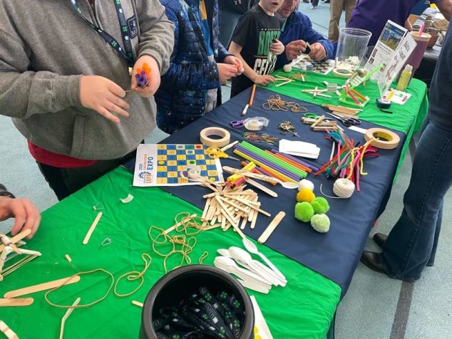 young students working at a table with items from a science toolkit at the Lafayette Science Center